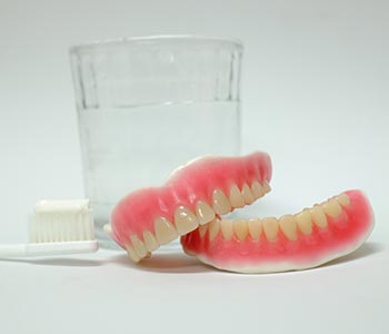 A dental crown is a covering of strong material such as porcelain or zirconia that encloses the visible portion of a tooth.